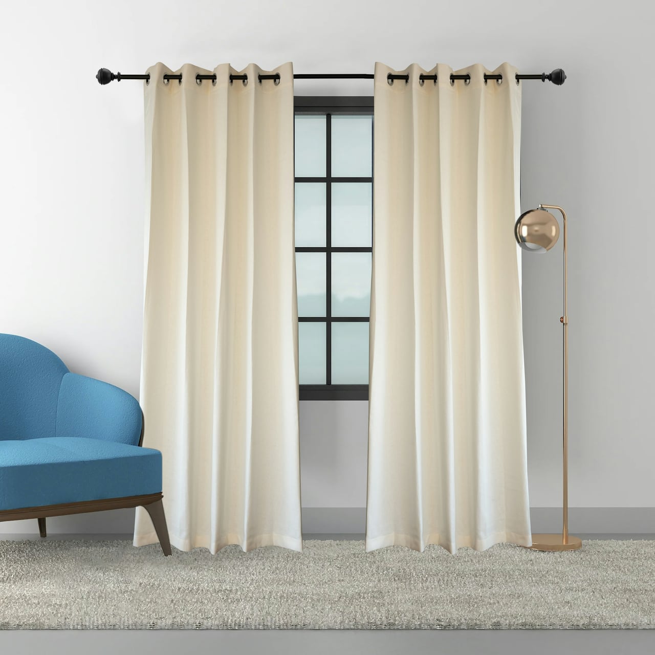 Cream drapes framing a window beside a blue upholstered chair and floor lamp