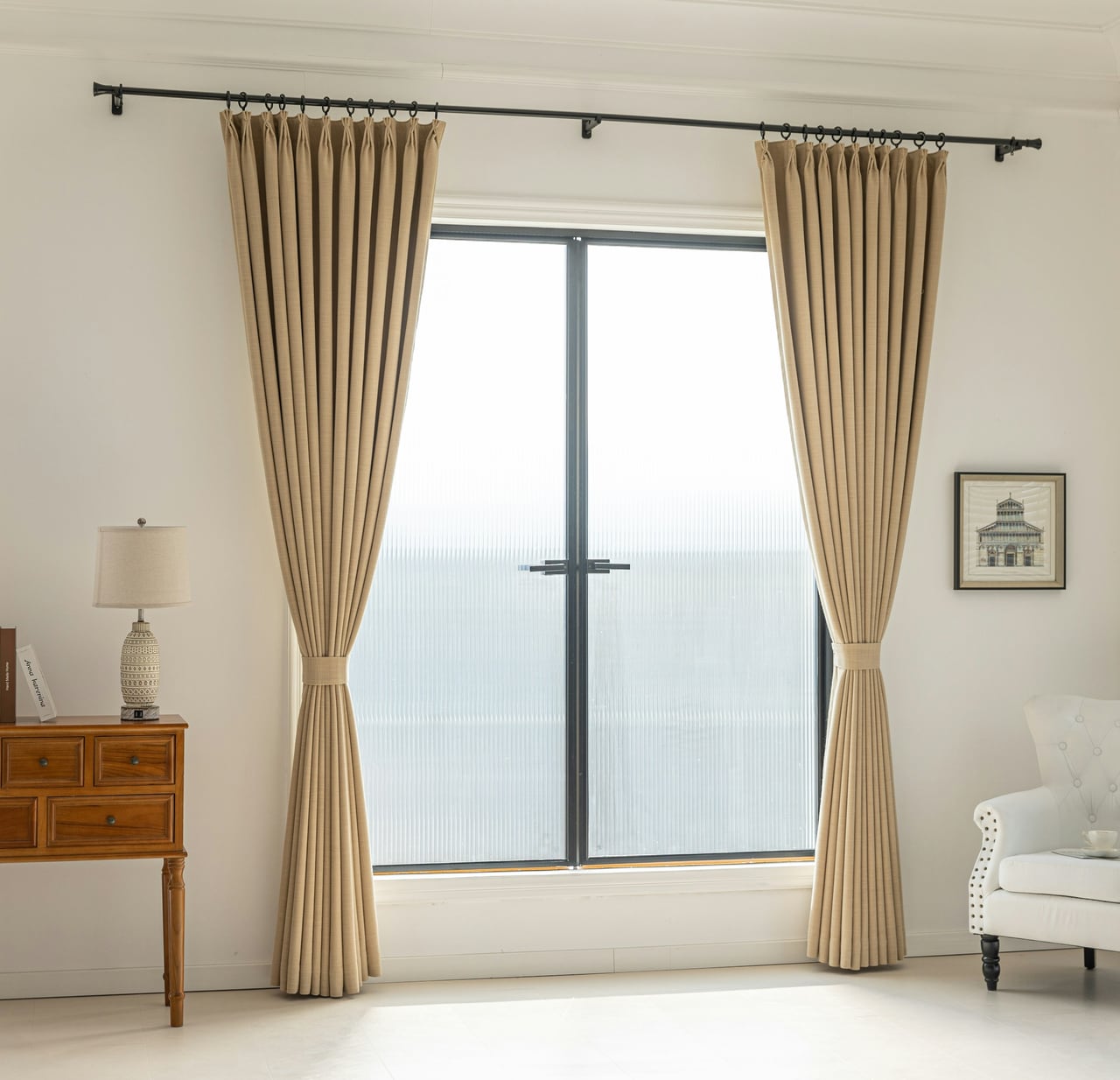 Floor-to-ceiling beige curtains tied back beside a bright multi-pane window