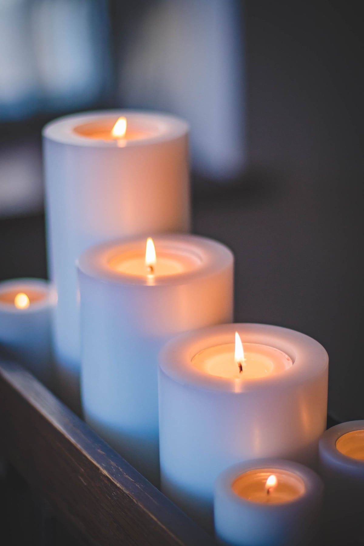 White pillar candles glowing in warm soft focus light